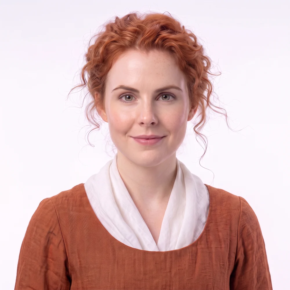 Colleen Crowley, head and shoulders: copper hair pinned up, a burnt-orange dress and a white linen fichu.